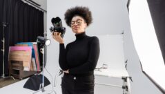 positive african american content maker in black turtleneck and eyeglasses standing with