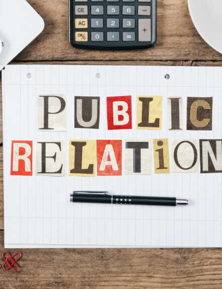 Public Relations title from newspaper cutout letters on paper notepad